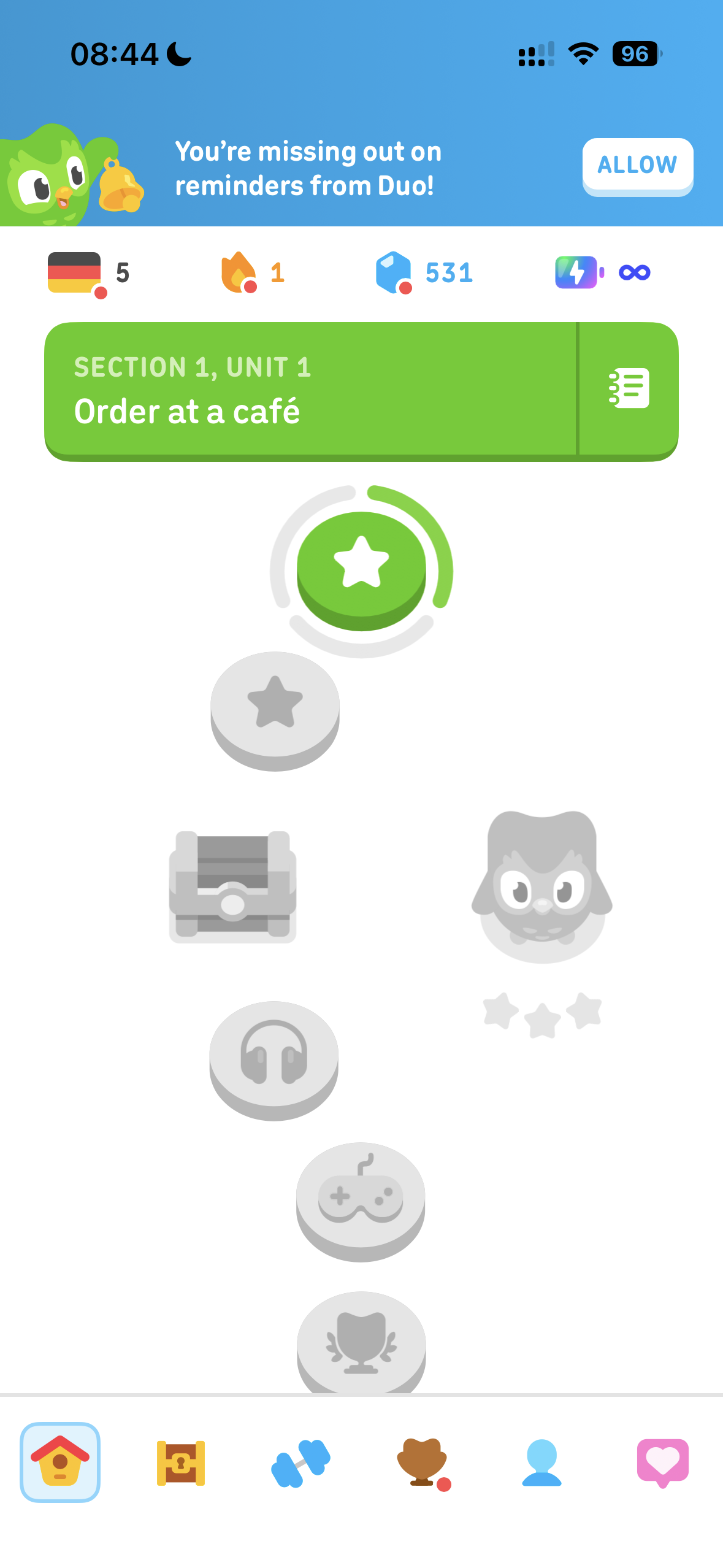 Duolingo German Section 1 Unit 1 learning path showing Order at a cafe, streak, gems, infinity hearts, and a reminders notification banner from a genuine paid-account session